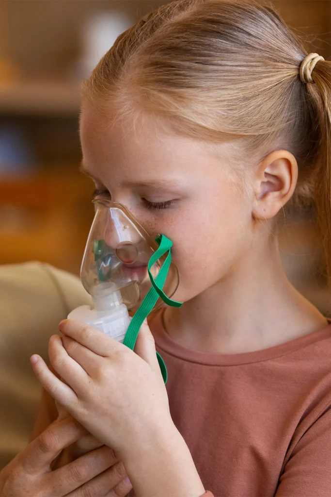 Woman Helps Young Girl Use A Nebulizer